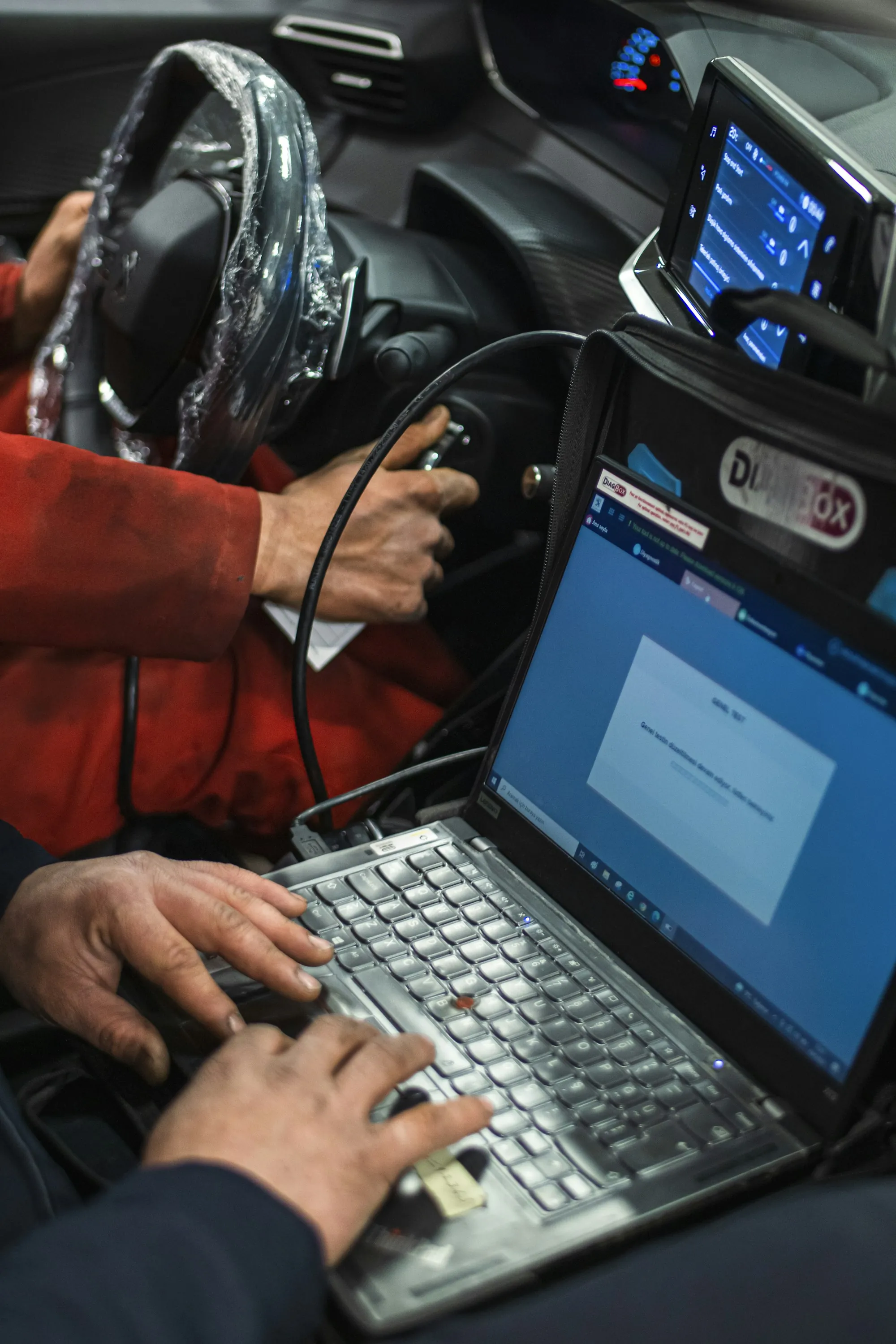 Laptop running diagnostic software on a vehicle's front seat