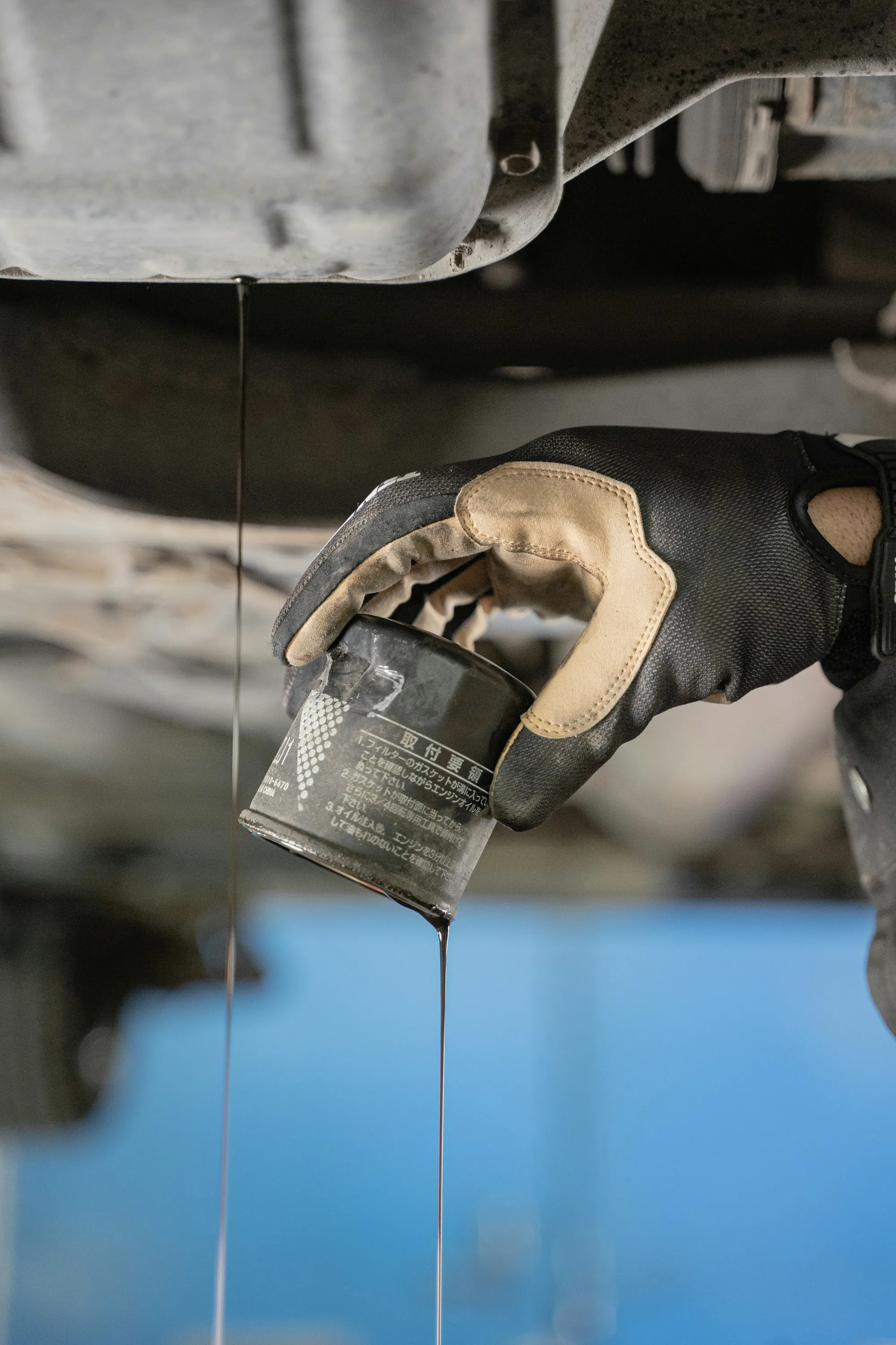 Mechanic removing a used oil filter during an oil change